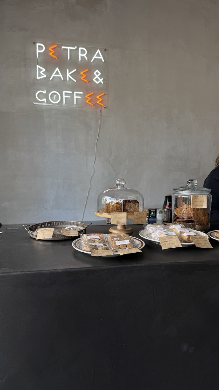 The counter at Petra Bake & Coffee, with its distinctive neon sign and a display of fresh baked goods.