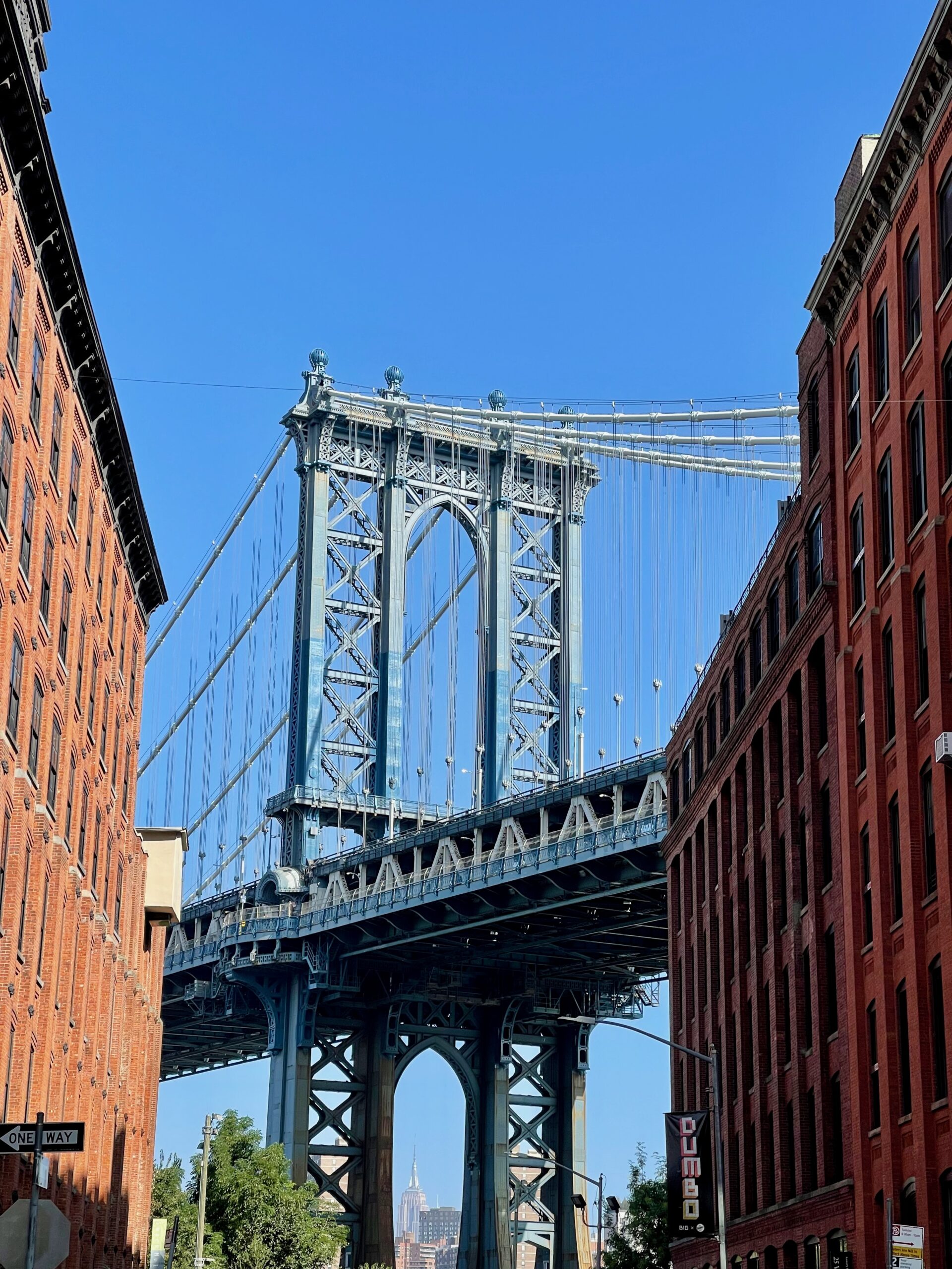 Manhattan Bridge framed by red-brick buildings in DUMBO.