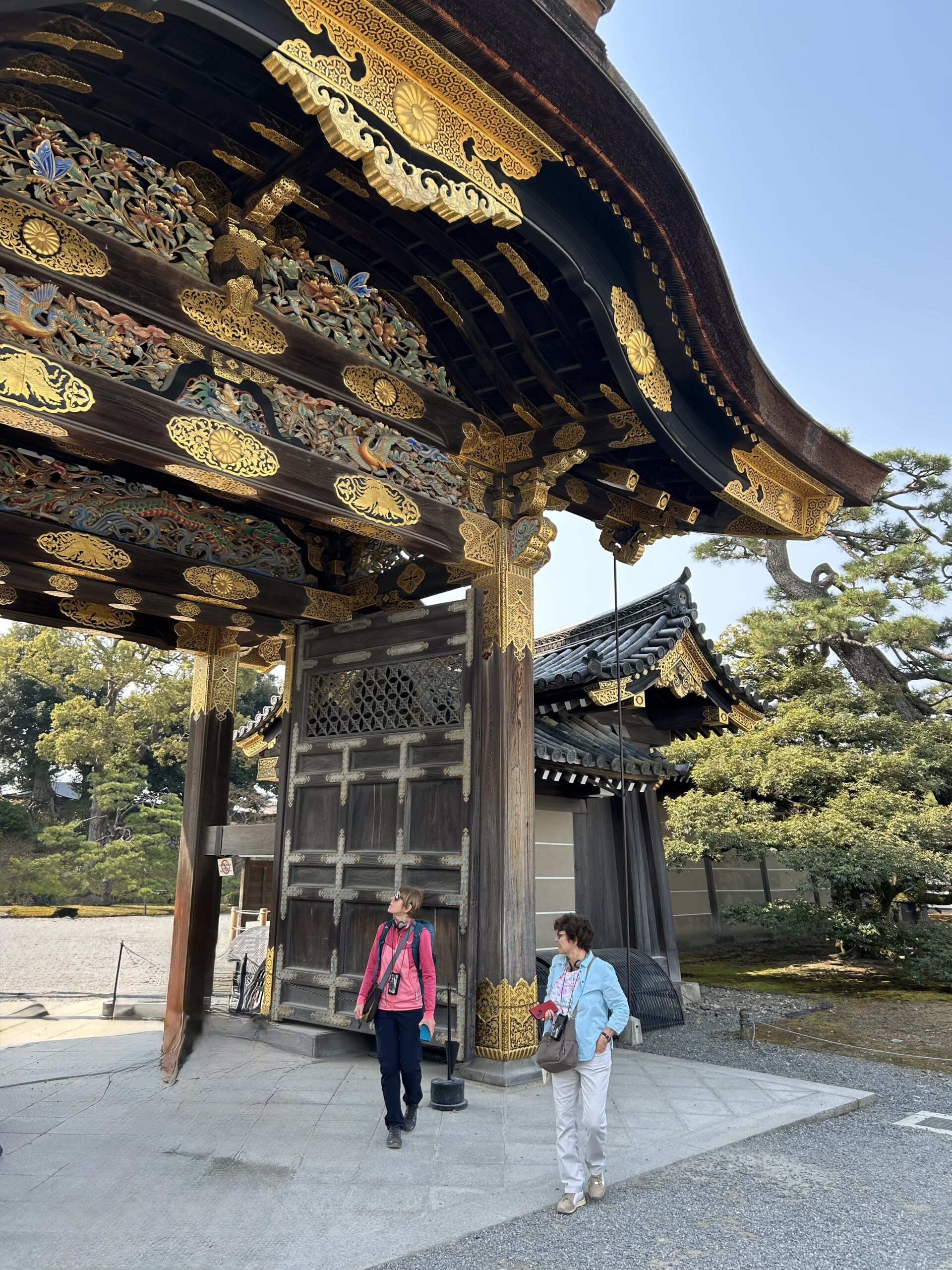 The gilded Karamon gate at Nijo Castle in Kyoto, with visitors passing beneath it.