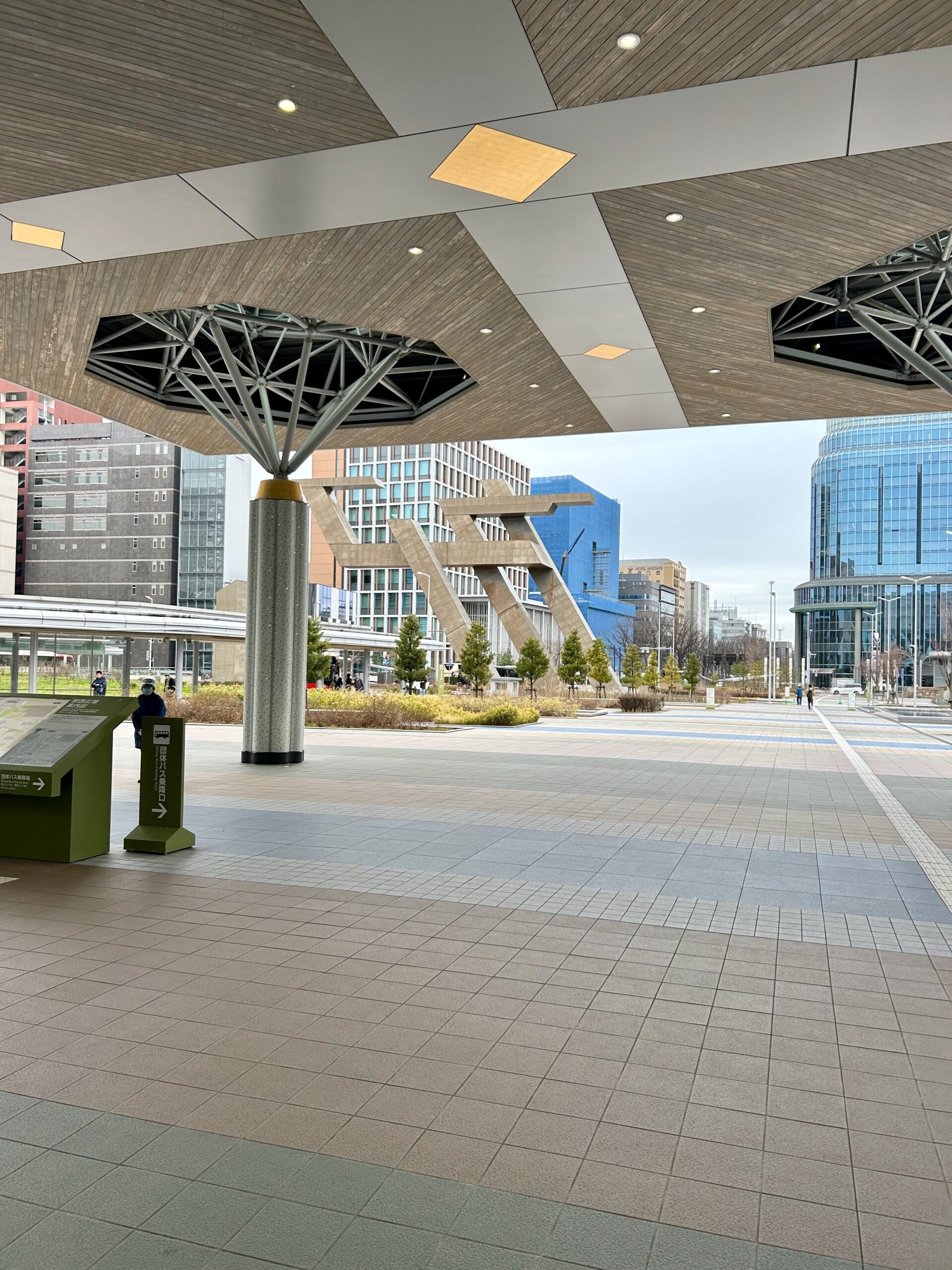 The forecourt of Kanazawa Station under its wooden canopy, looking out toward the city.