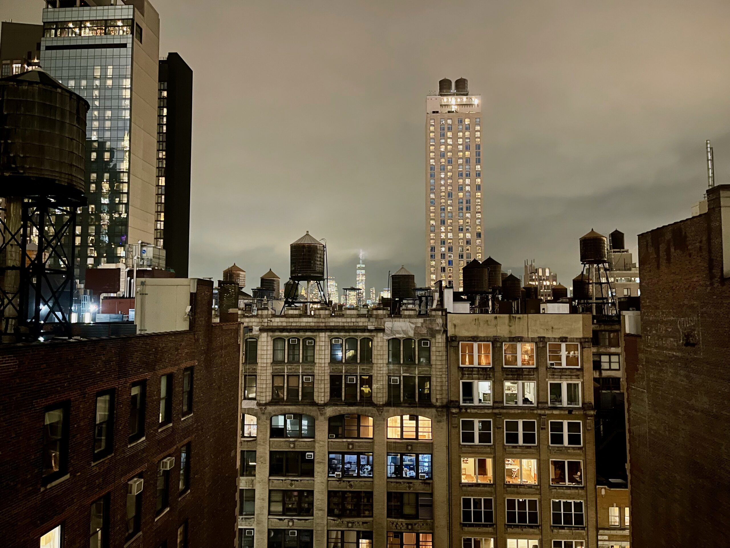 Night view from room 1618 at Innside New York NoMad, with rooftop water tanks and Manhattan buildings.